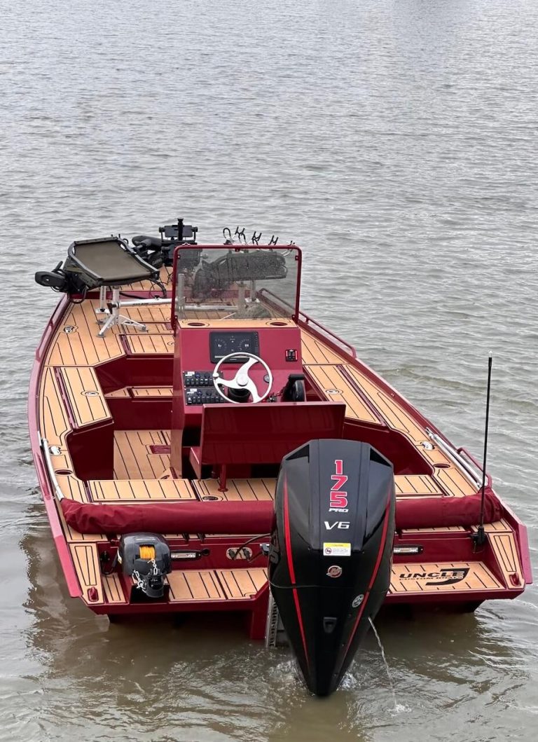 Red bay boat with wood-look decking, a center console and a 125 V6 outboard