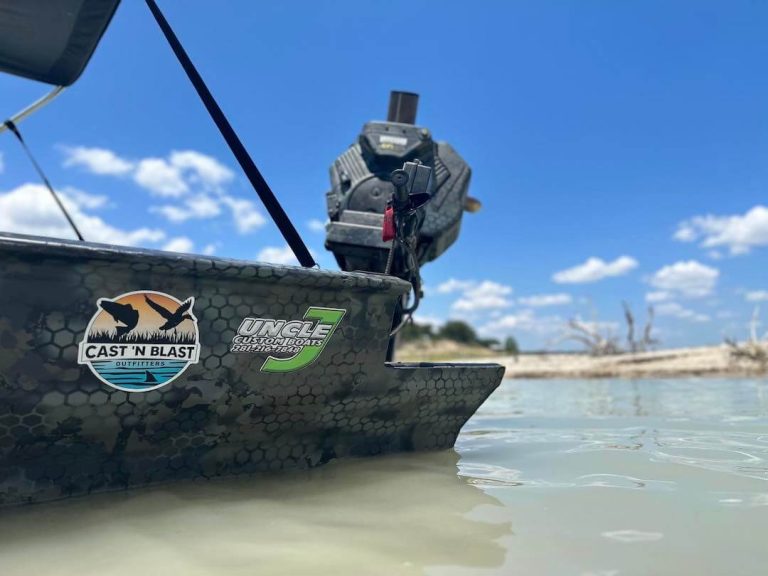 Bow of the Cast 'N Blast Outfitters boat with its Uncle J logo, on the water