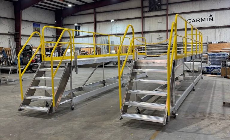 Two aluminum work platforms with stairs and yellow handrails