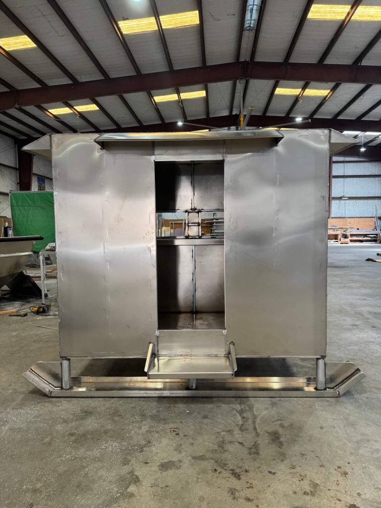 Front of an aluminum enclosure on skids with its door open